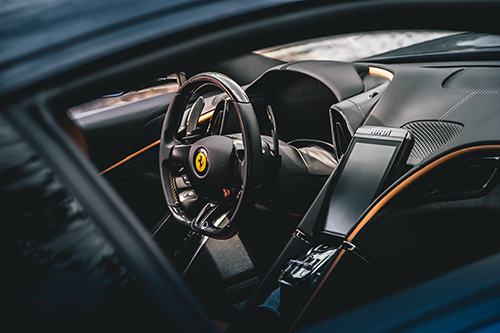 Ferrari steering wheel and carbon fiber interior detail photographed for a luxury automotive brand campaign