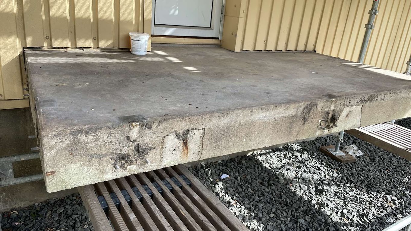 Skadad betong längs balkongplattans framkant på Föreningsgatan före renovering