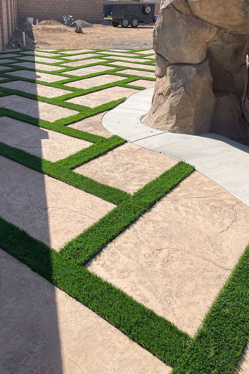 A patio made of cement, creatively combined with squares of artificial grass.