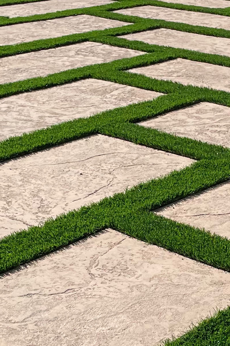A patio made of cement, creatively combined with squares of artificial grass.