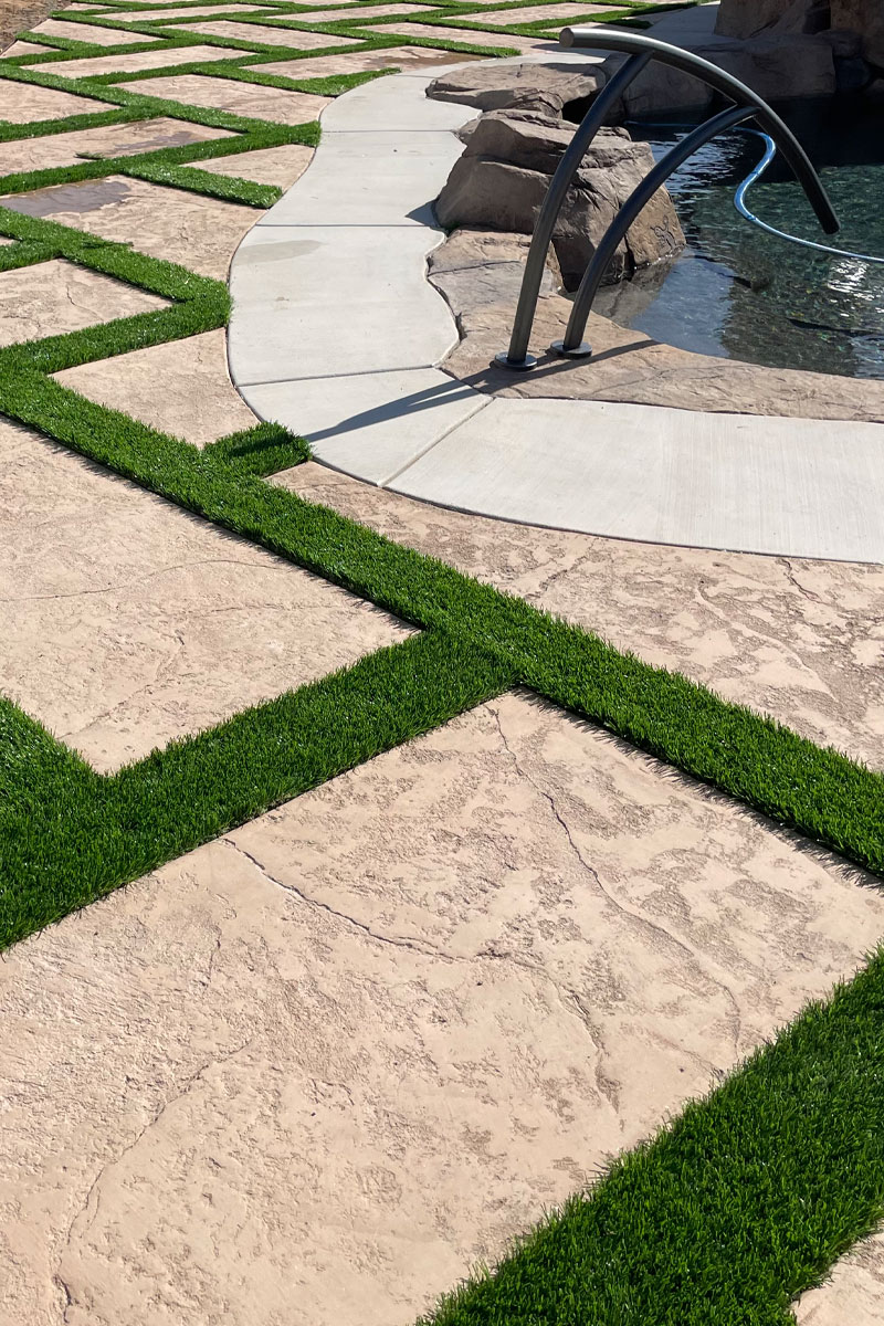 A patio made of cement, creatively combined with squares of artificial grass.