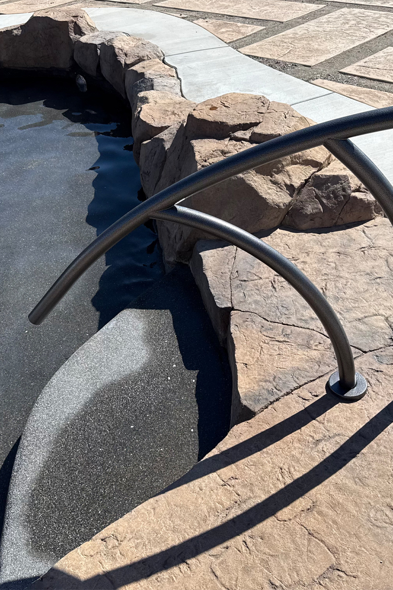 Metal handrails designed for easy and safe entry into a swimming pool.