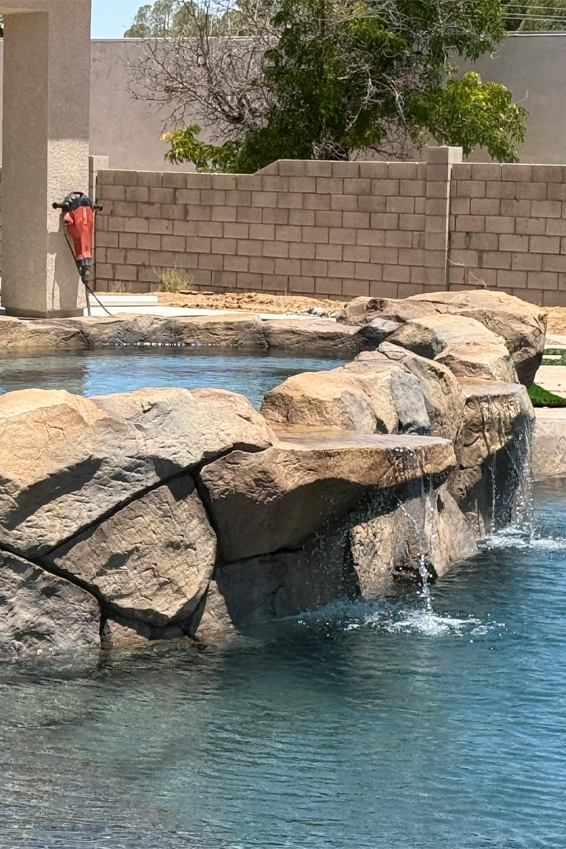 A swimming pool with a perimeter entirely surrounded by stones.