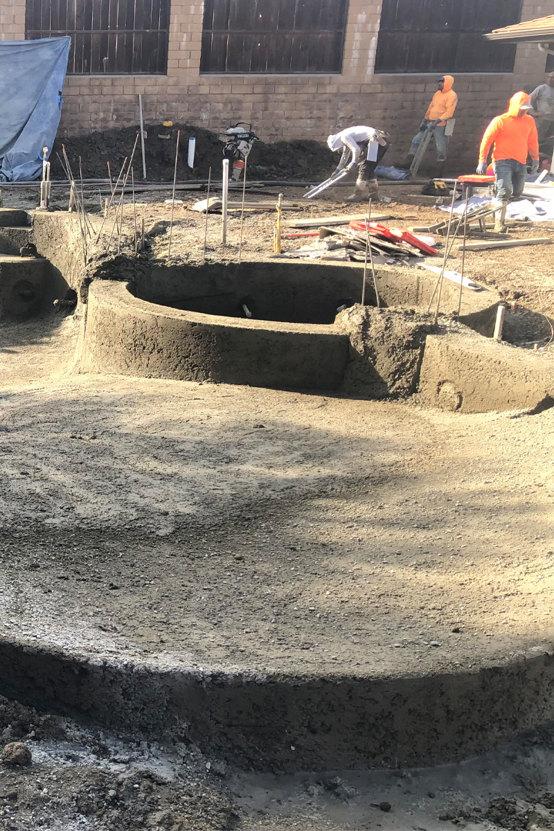 Construction workers are performing various tasks.