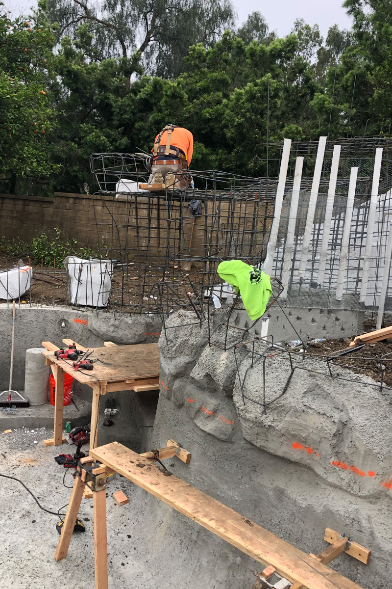 A person is constructing an iron framework, likely for the cave