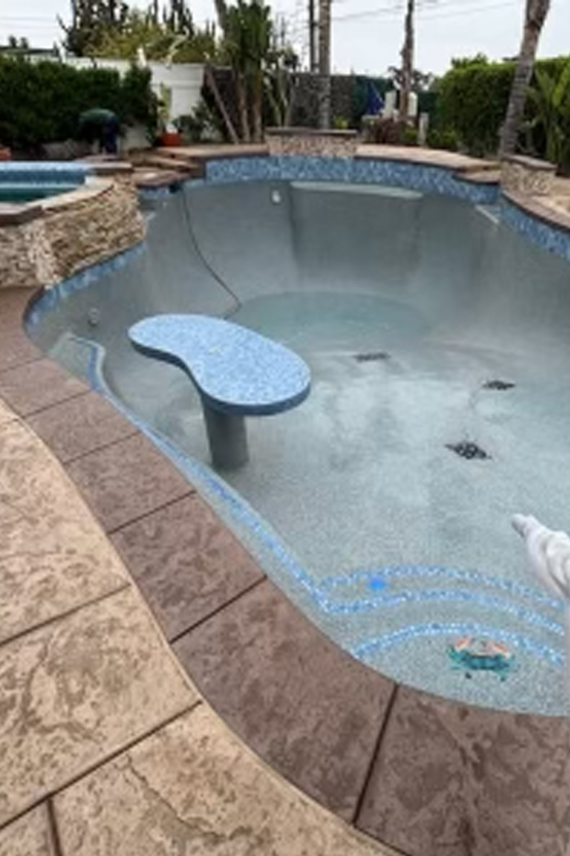 A newly constructed, empty swimming pool with a vibrant blue finish.