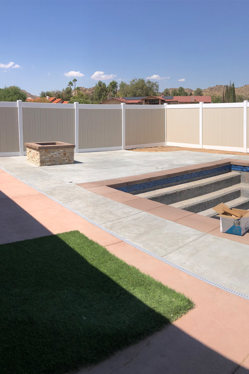 A section of a swimming pool wall under construction, with a fireplace also being built, and an open view of the sky.

