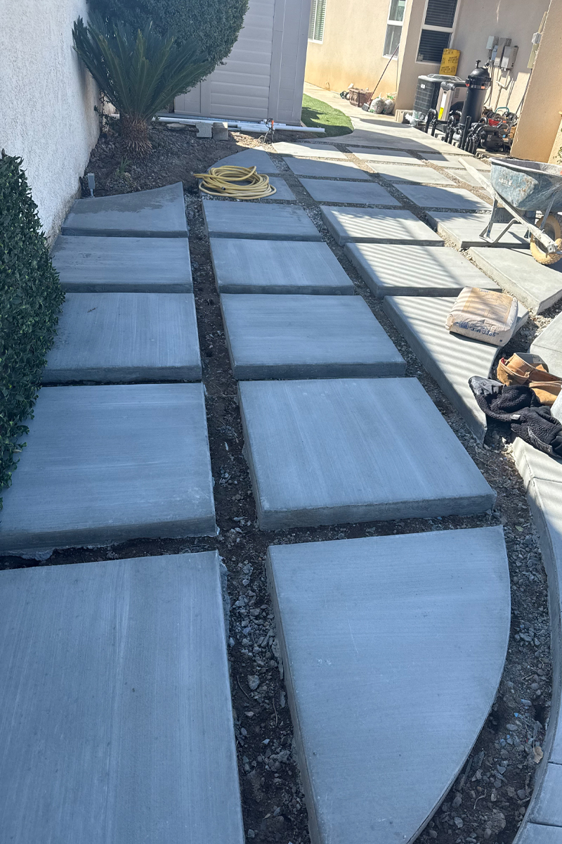 A patio under construction with freshly poured cement squares.