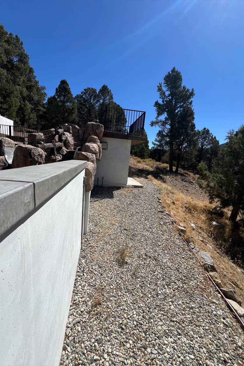 An exterior view looking up towards the sky, with the ground covered in small decorative stones.