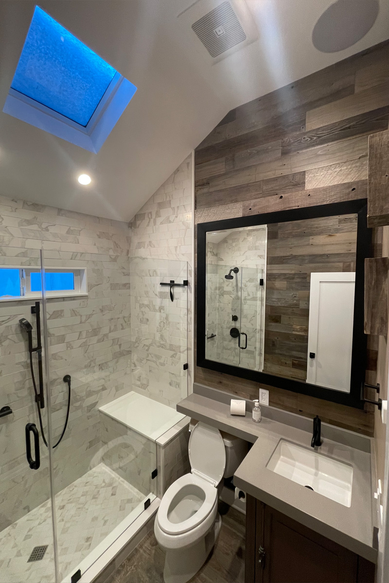 A compact and functional bathroom space where the toilet, sink, and shower are all seamlessly integrated into one area.
