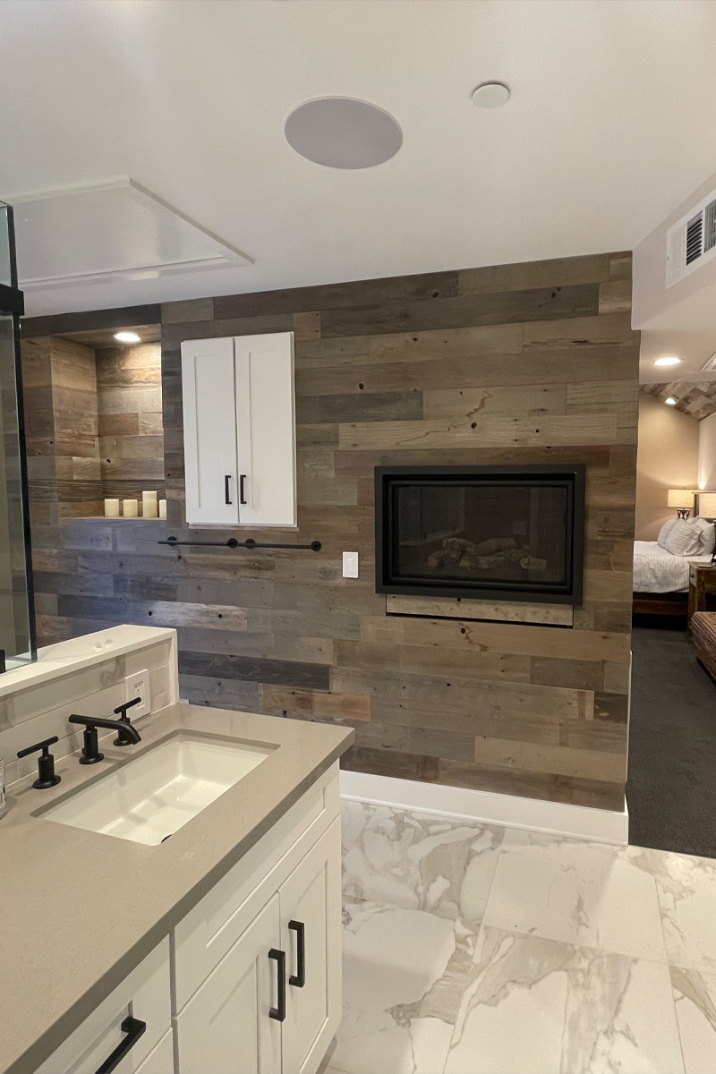 A wall constructed entirely of wood, featuring a modern fireplace seamlessly integrated into its structure.