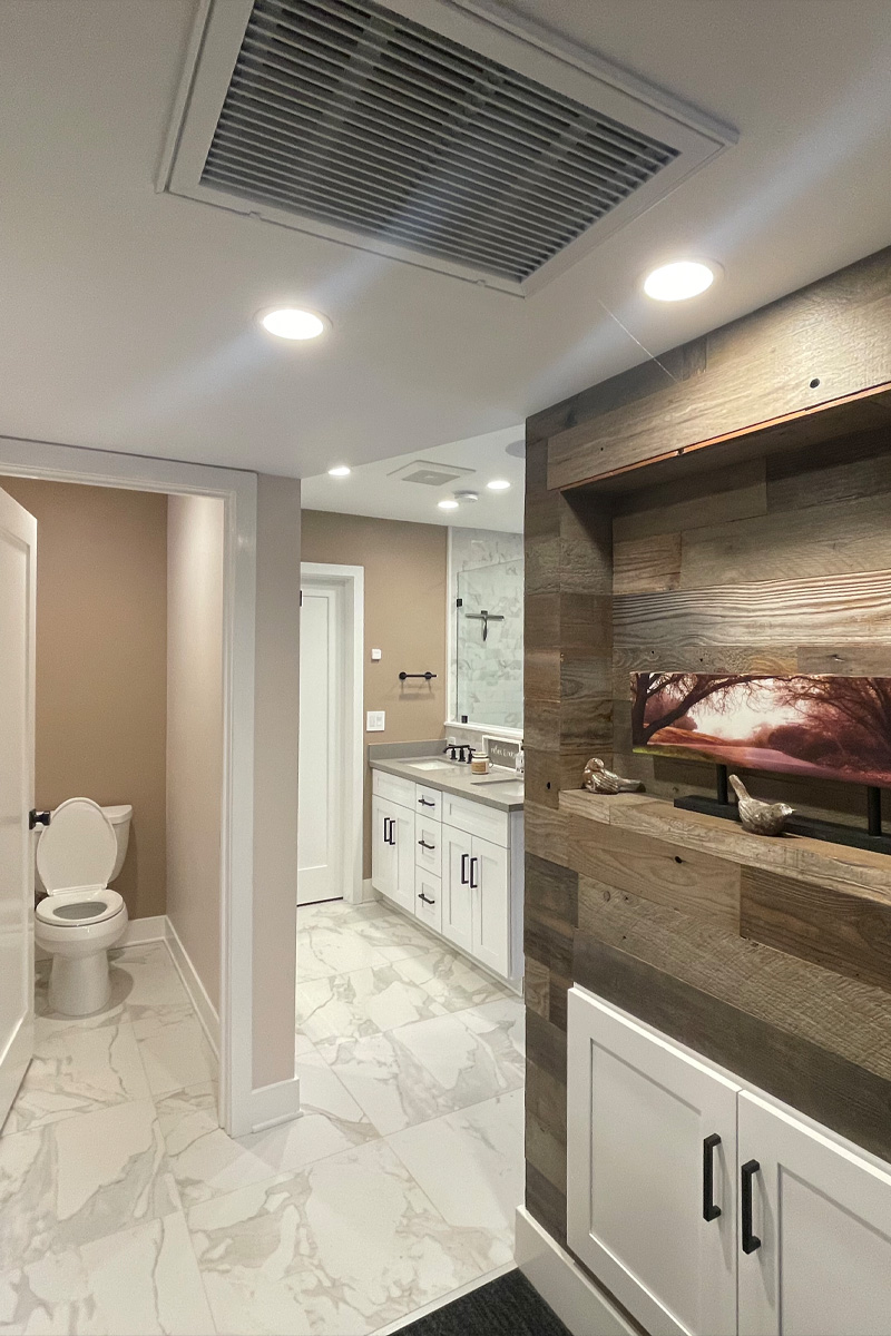 A luxurious bathroom designed with separate areas for the toilet and a double vanity. Decorative wooden structures are integrated into the design, adding warmth and elegance to the space.