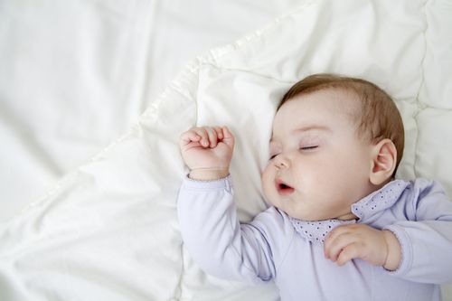 a cute baby sleeping with her mouth open
