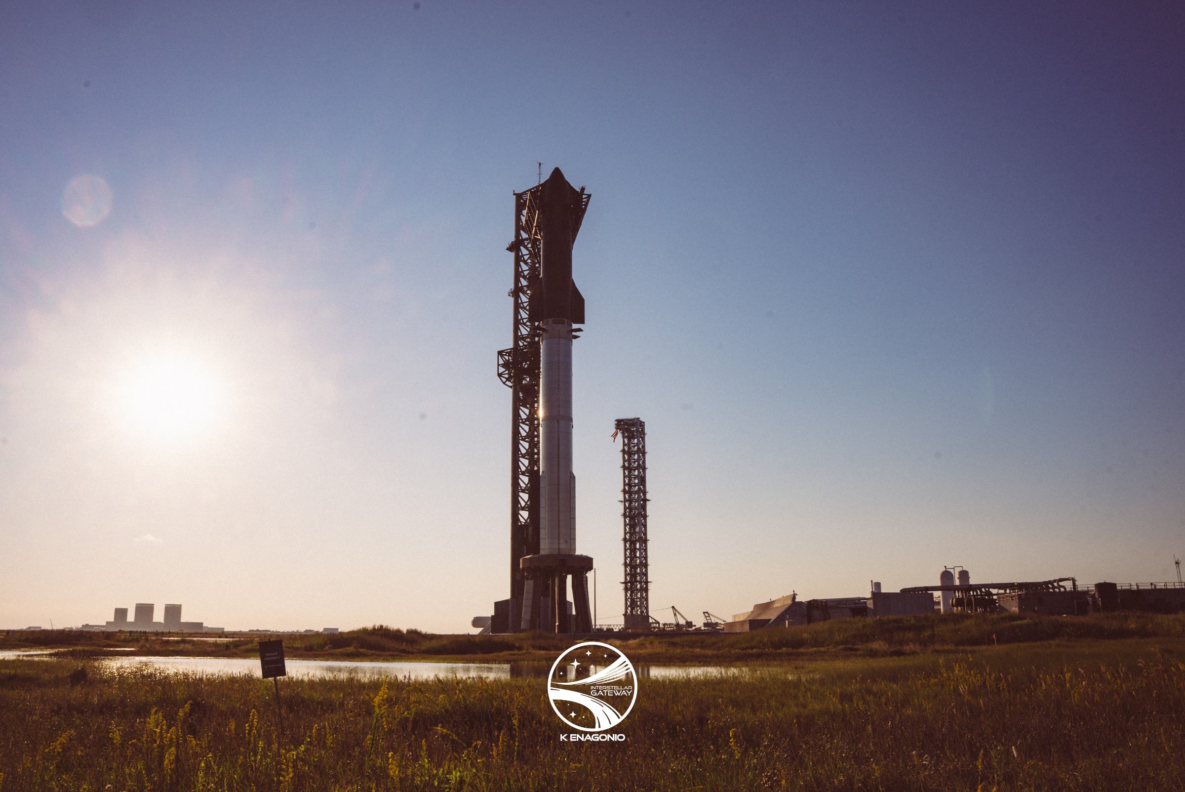 The full Starship stack on its launch mount at Starbase in low evening light.