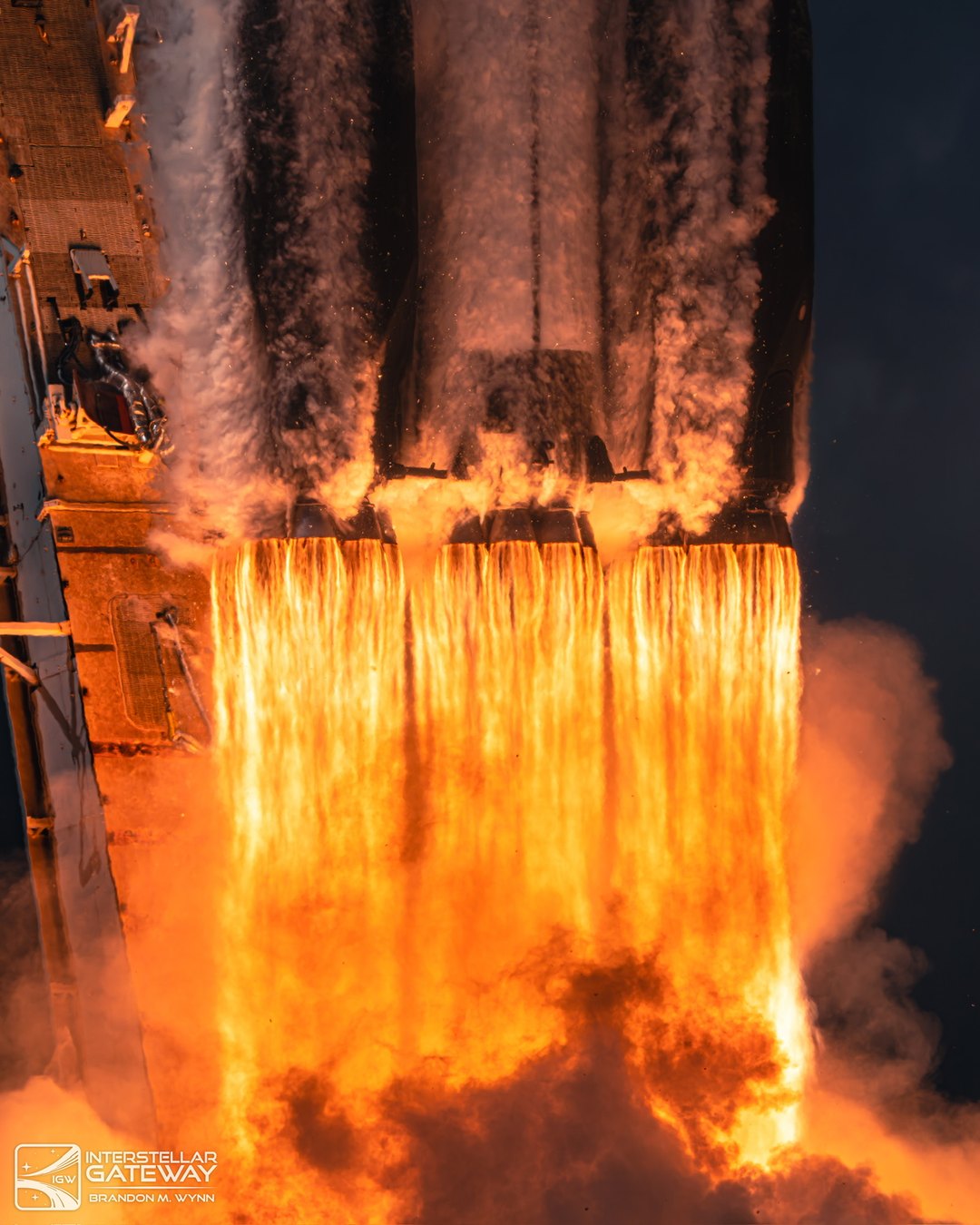 The Space Launch System clears the tower, exhaust pouring from the boosters and core stage.