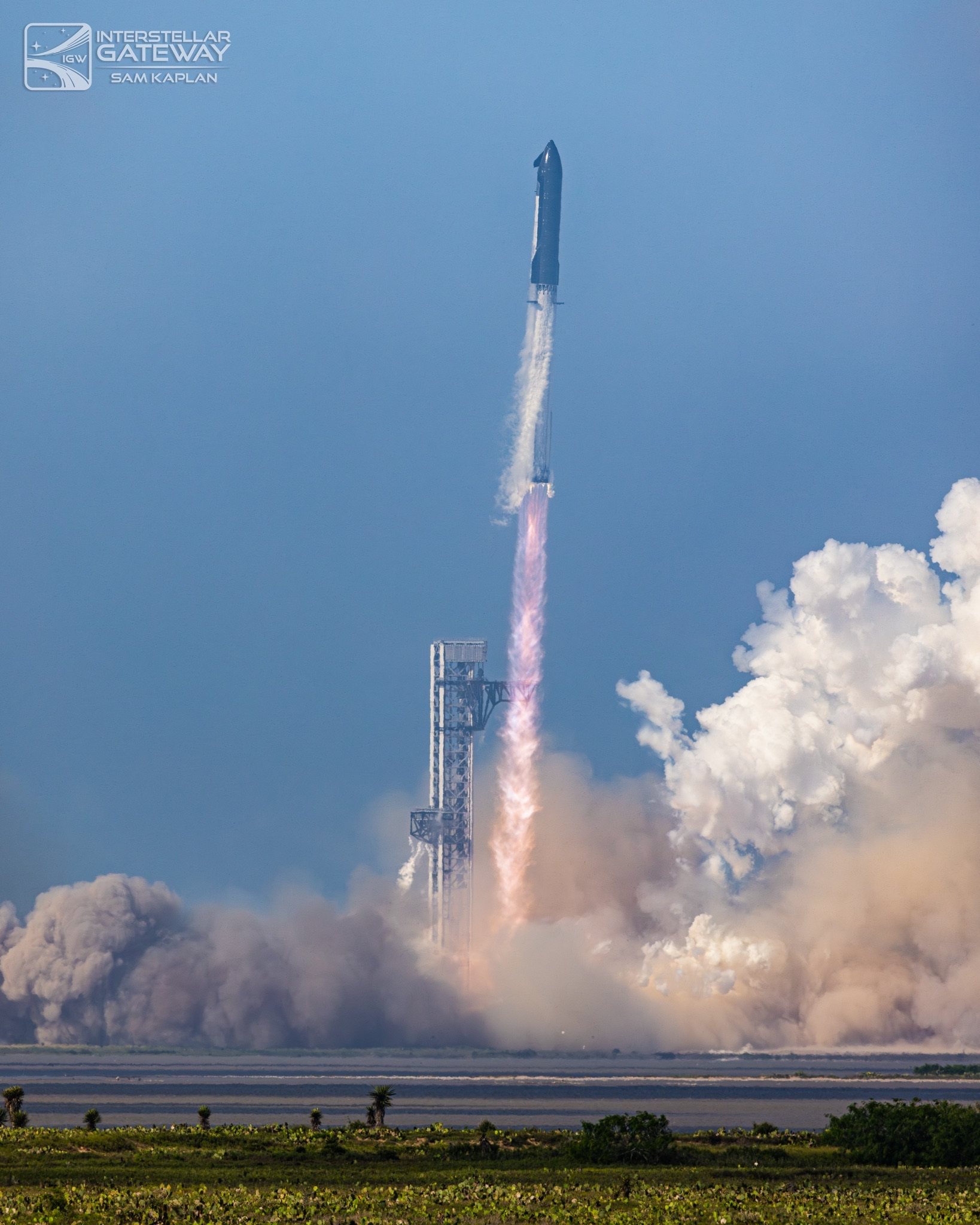 Starship lifts off from Starbase, clearing the tower on a bright plume.