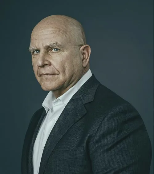 Portrait of a bald middle-aged man wearing a dark suit jacket and white shirt against a dark background.
