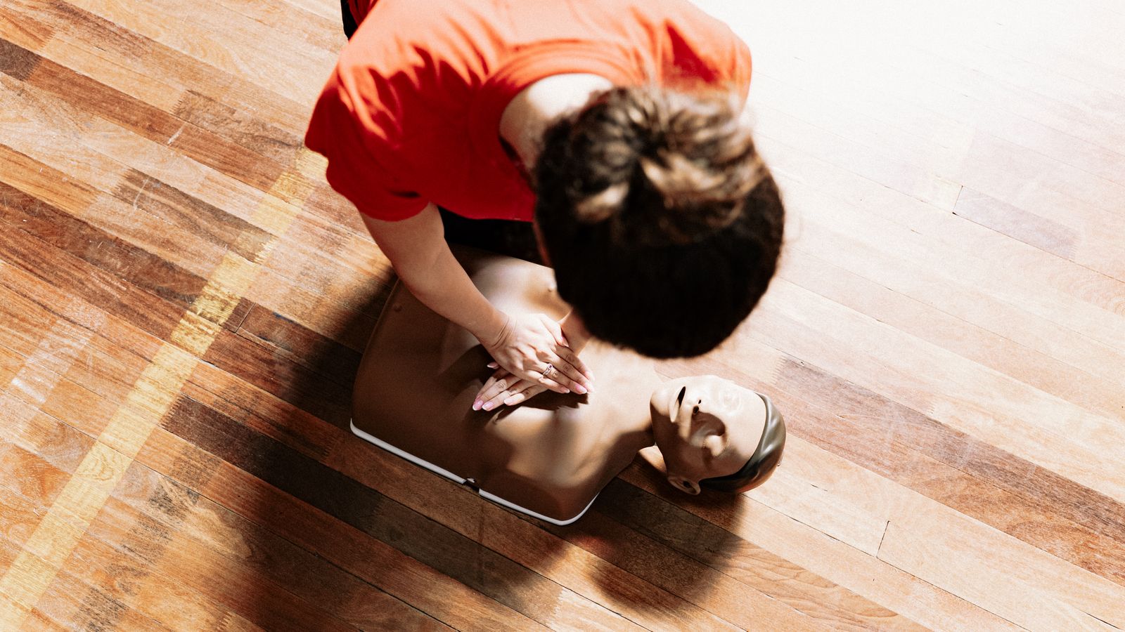 Un formateur montre les gestes de réanimation sur un mannequin pendant une formation aux premiers secours