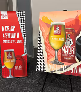 Two promotional posters featuring Madri Exceptional Spanish style lager with images of the beer in a glass and a can, set against colorful backgrounds.