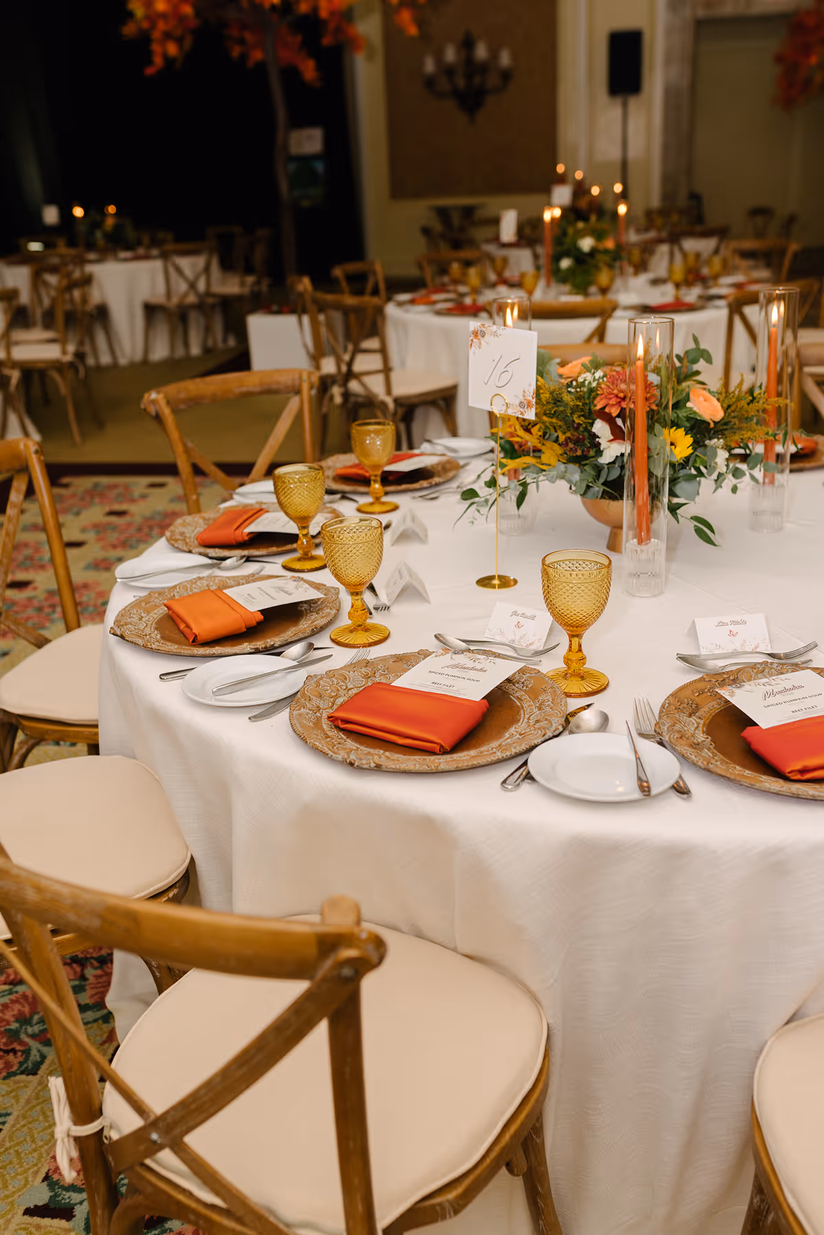 a beautifully set table for a formal event, likely a wedding or awards celebration, featuring a warm, autumn-inspired color palette.