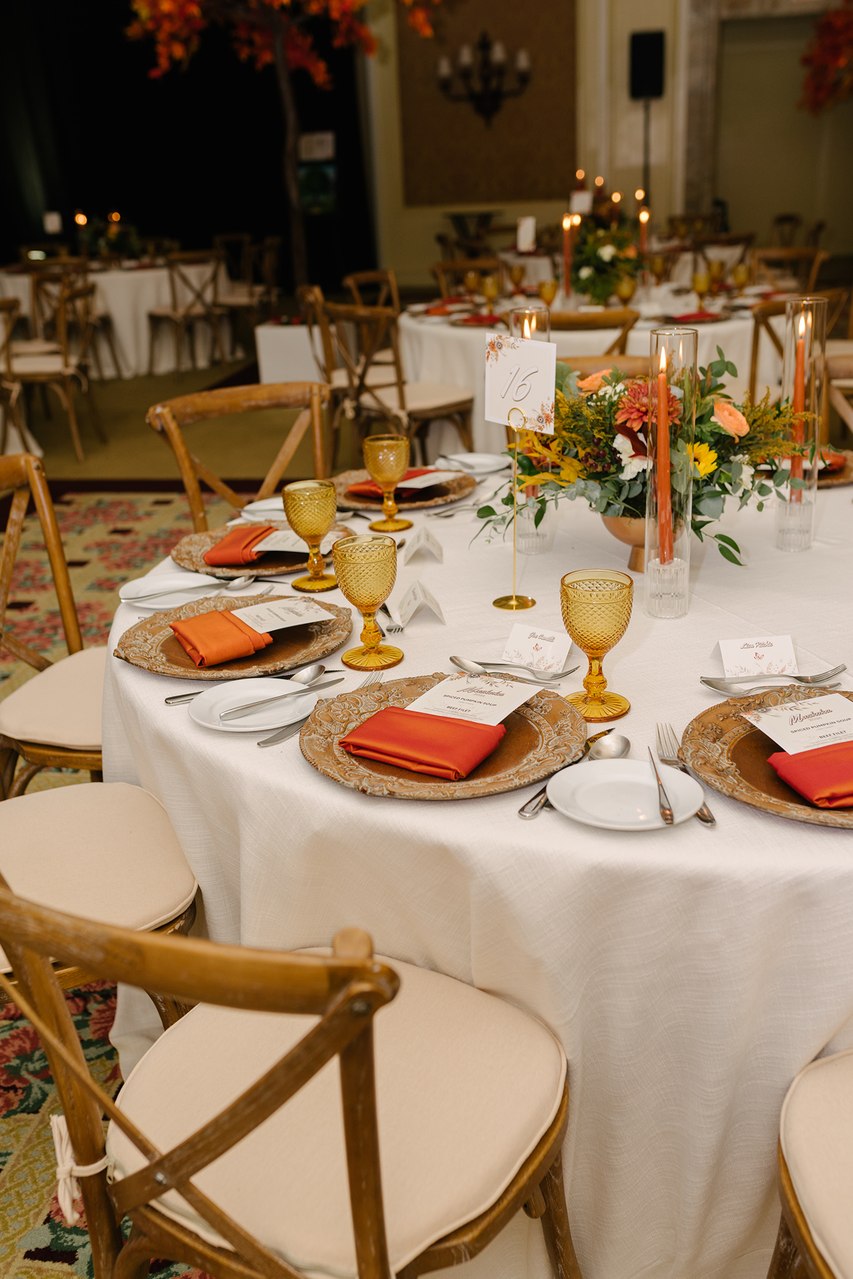 a beautifully set table for a formal event, likely a wedding or awards celebration, featuring a warm, autumn-inspired color palette.