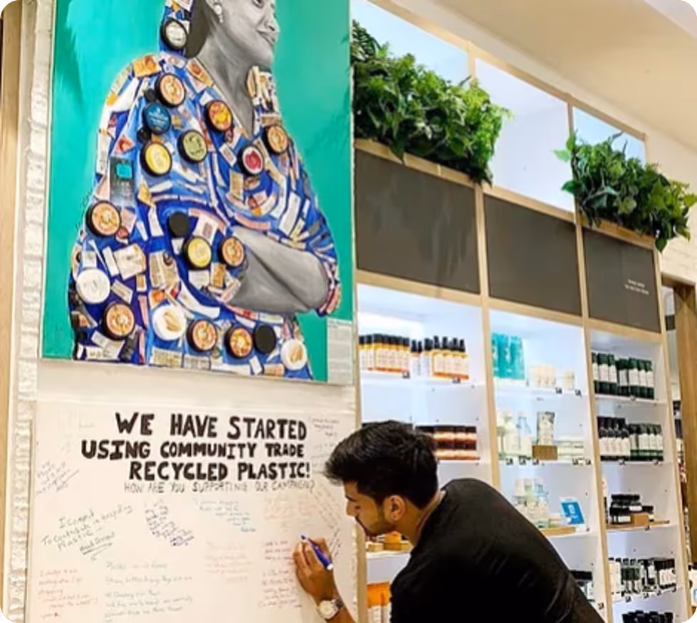 Eco‑friendly Toronto team building activity with employees writing pledges on recycled plastic campaign board