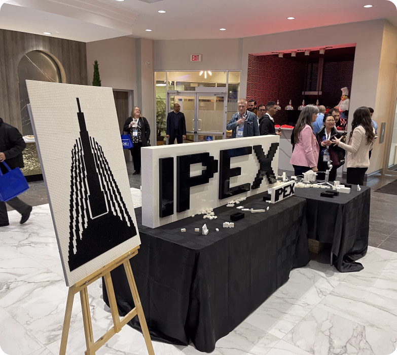 Event display with LEGO installation spelling IPEX and mosaic skyscraper design