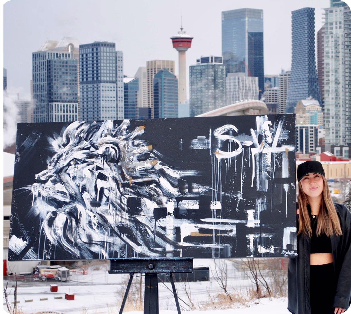 Person standing beside abstract lion painting on easel in snowy urban setting