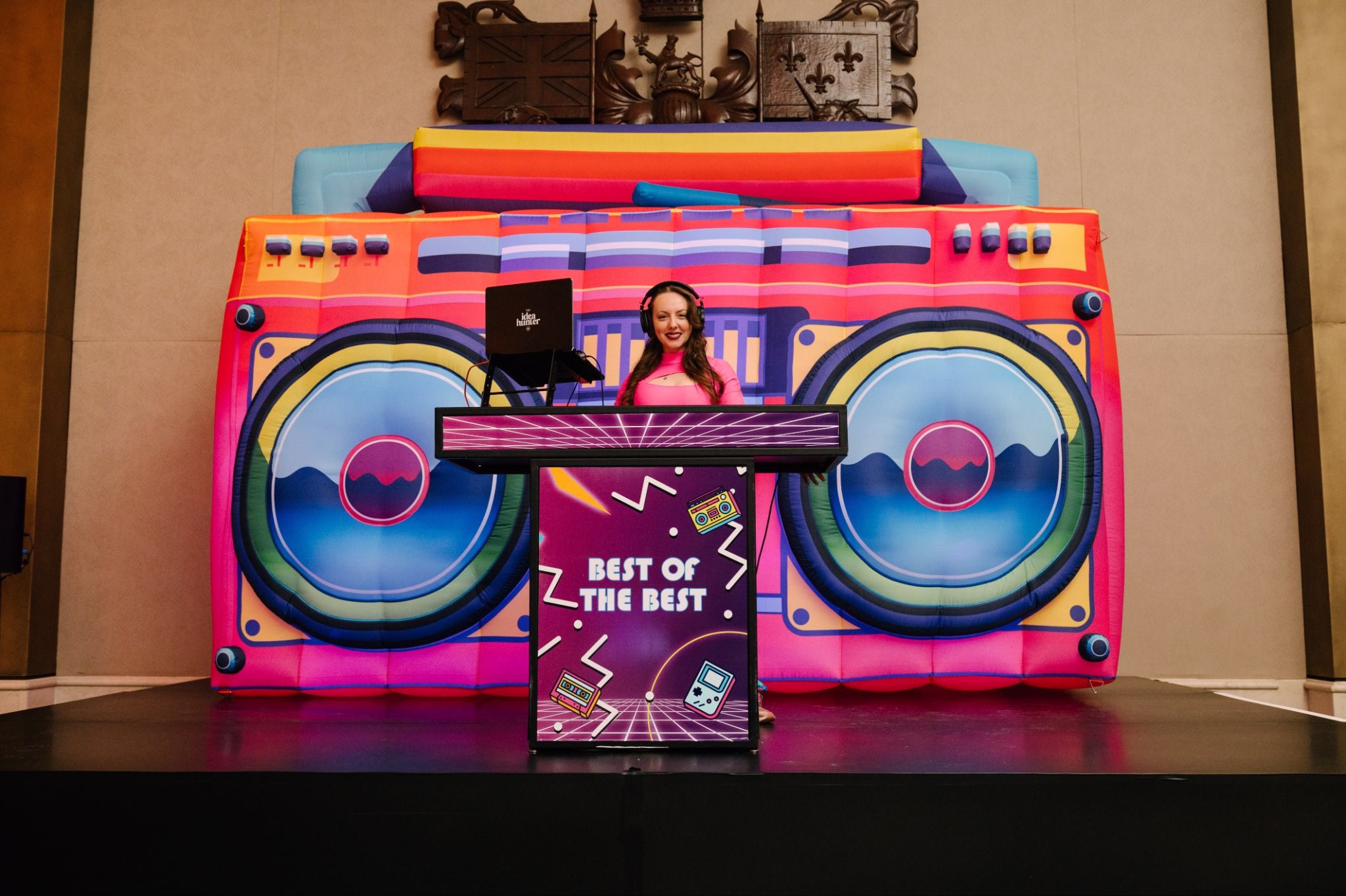 DJ performing at booth with colorful retro boombox inflatable backdrop