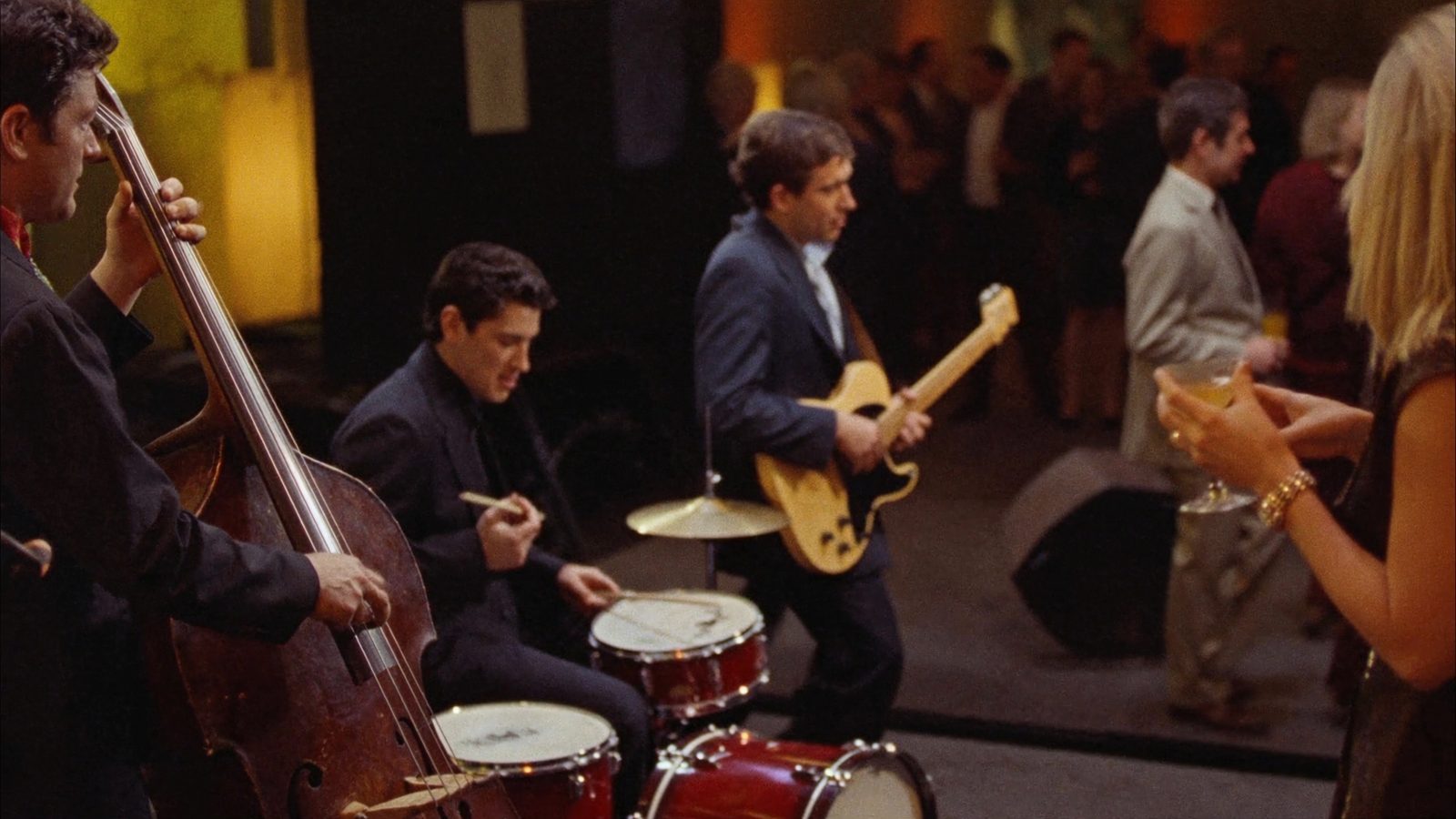Jazz trio with upright bass, guitar and drums playing for guests at a corporate holiday party