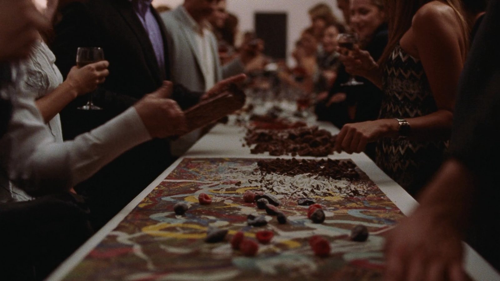 Painted chocolate slab on a long table with guests choosing toppings