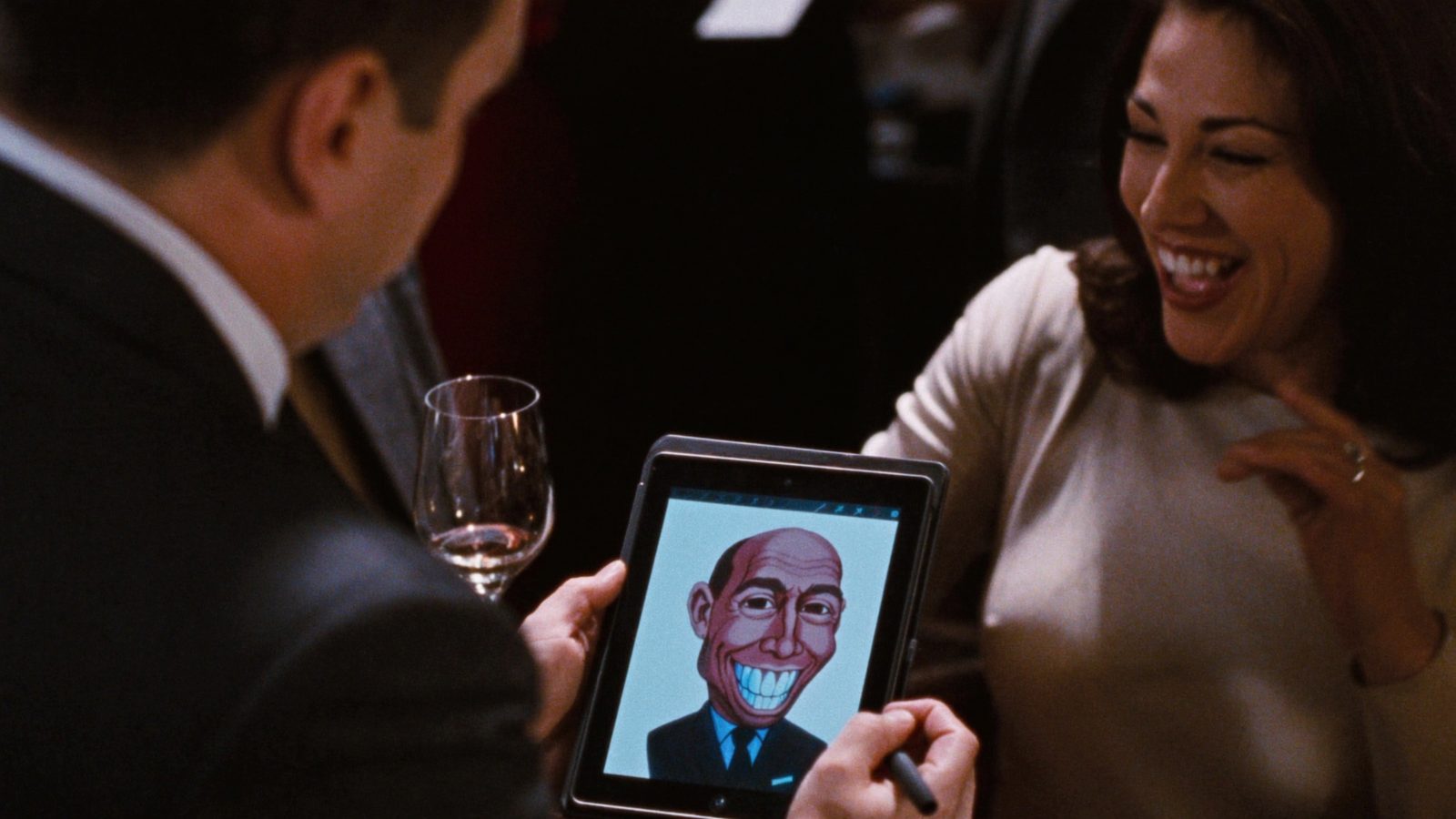 Artist drawing a digital caricature of a laughing guest on a tablet