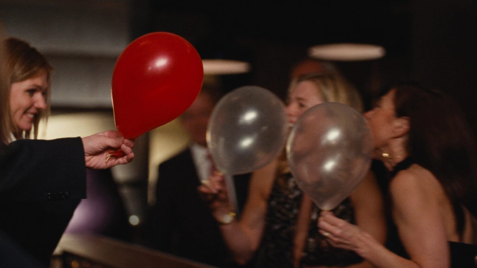 Guests laughing as an attendant hands out edible helium balloons
