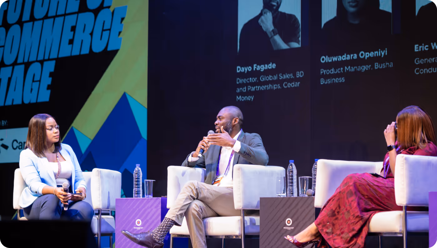 Three panelists seated on stage engaged in a discussion at the Future of Commerce event, with visible speaker profiles and microphones.