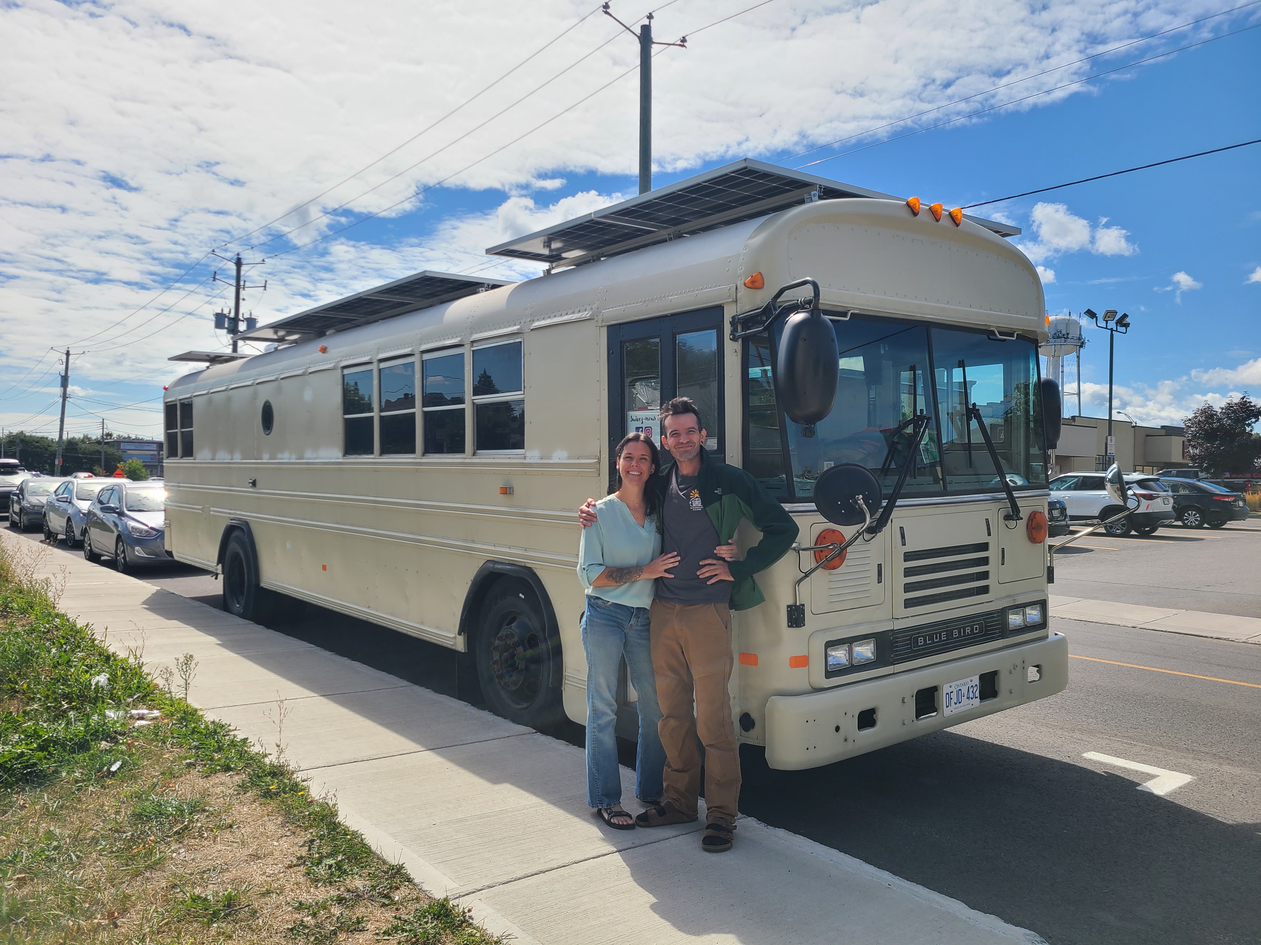 Cindy and Luc from Alternative Solaire standing in front of their solar bus