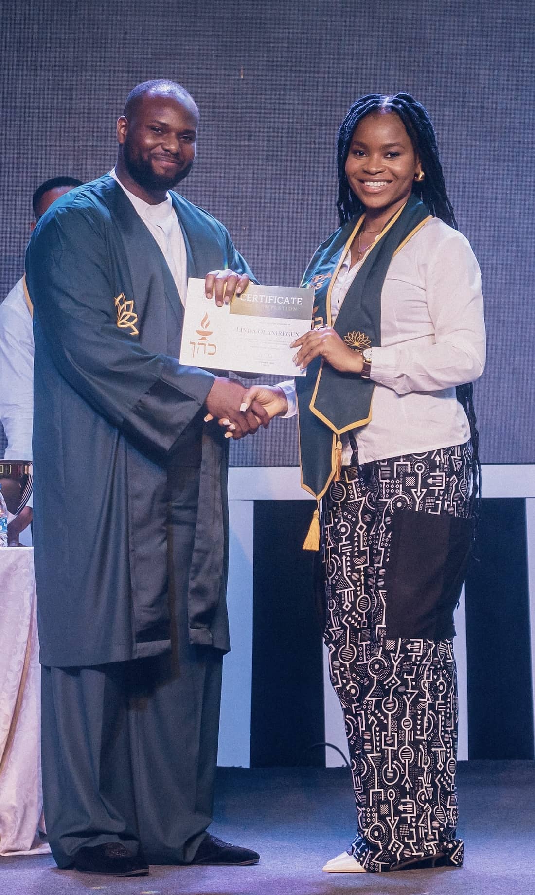 Portrait of a student receiving their certificate from our teacher at the graduation ceremony of the workplace altar