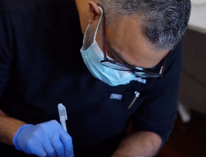 Hair transplant specialist carefully creating recipient sites during a beard restoration procedure.