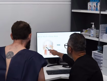 Hair transplant specialist explaining the hair restoration procedure during a patient consultation.
