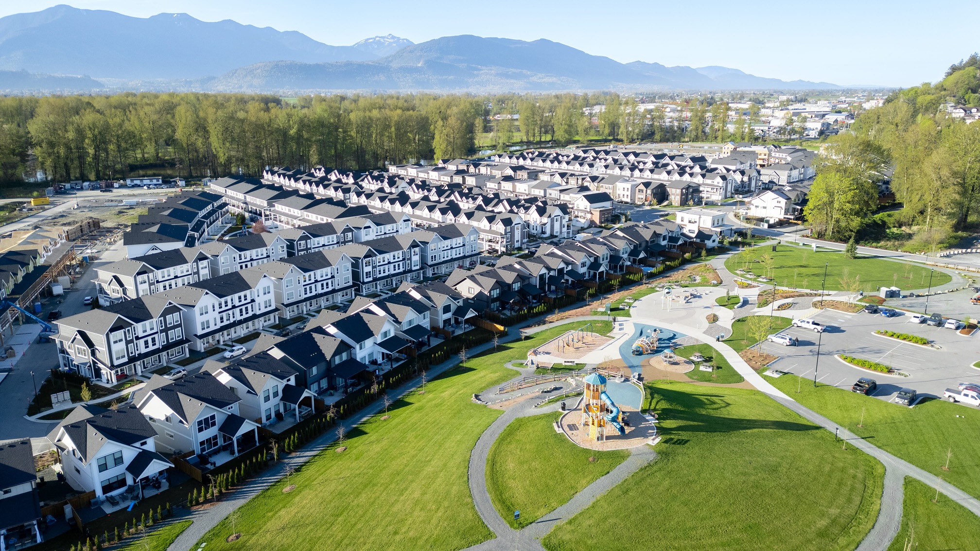 Aerial view of Chilliwack town houses community with park, playground and mountain views.