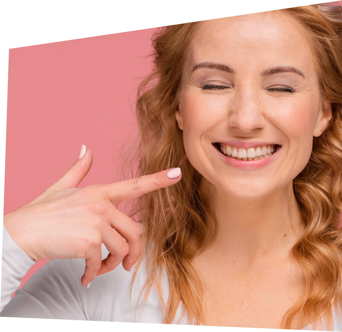 Woman smiling pointing at her perfect teeth