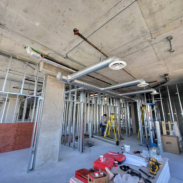The clinic under construction: steel framing up, ductwork going in, concrete still bare