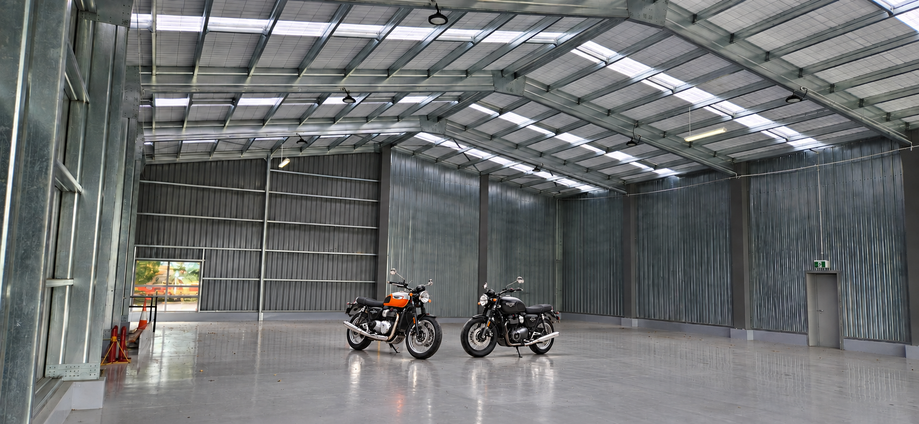 Two motorcycles parked in a large hangar