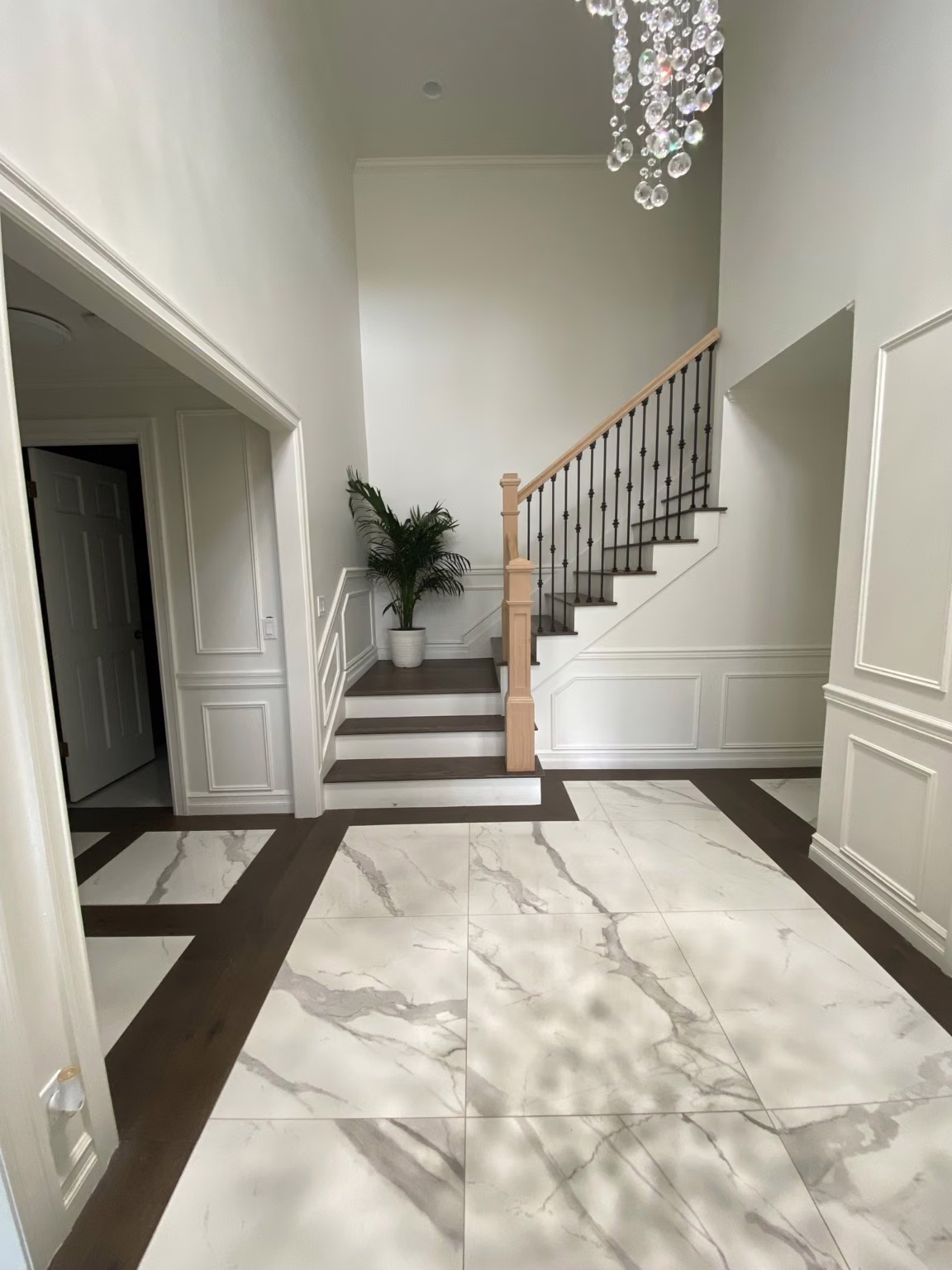 Finished Bellevue entry and staircase with light tile and dark wood borders