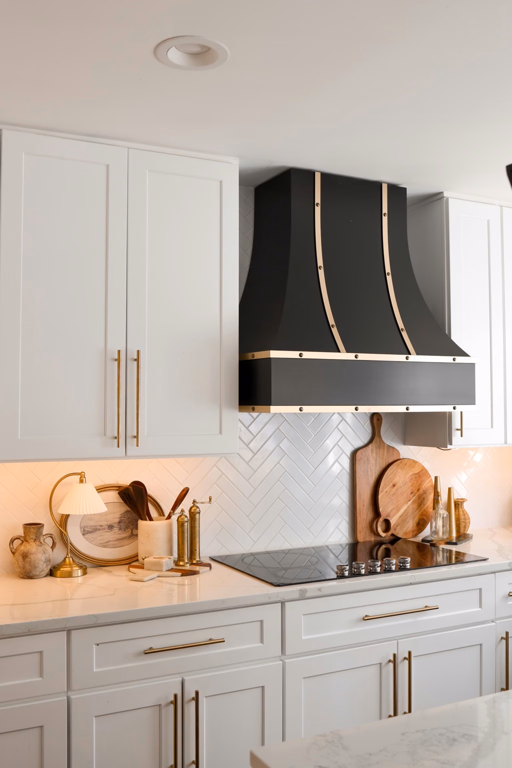 Bellevue kitchen range hood, cabinet fronts and warm metal details