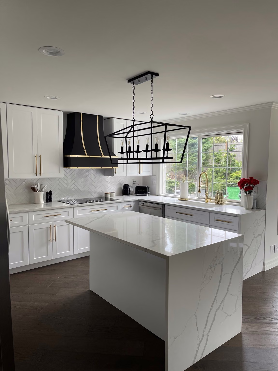 Kitchen remodeling in Bellevue with white cabinets, dark range hood and a finished island