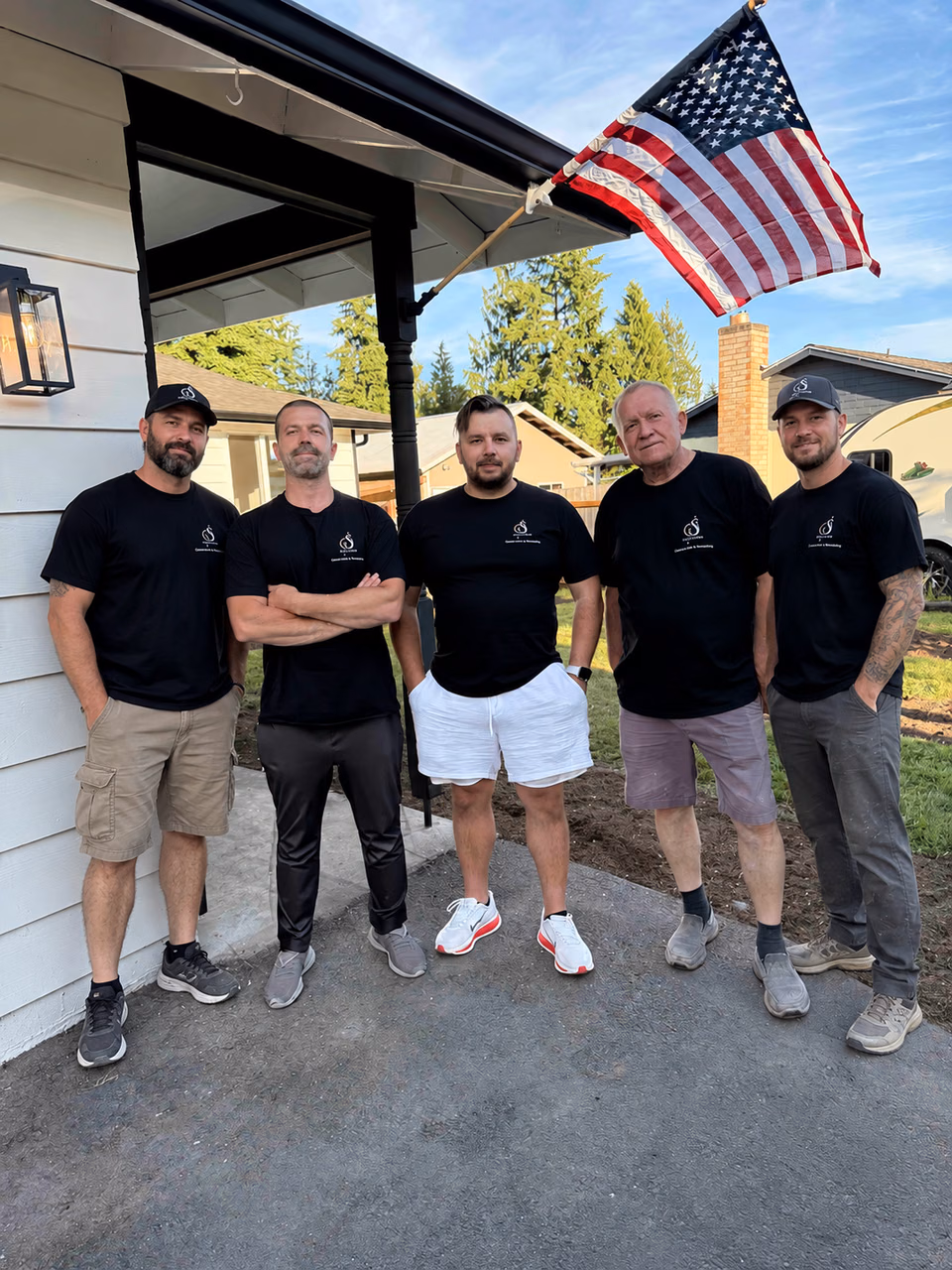The Oleg and Sons remodeling team outside a home