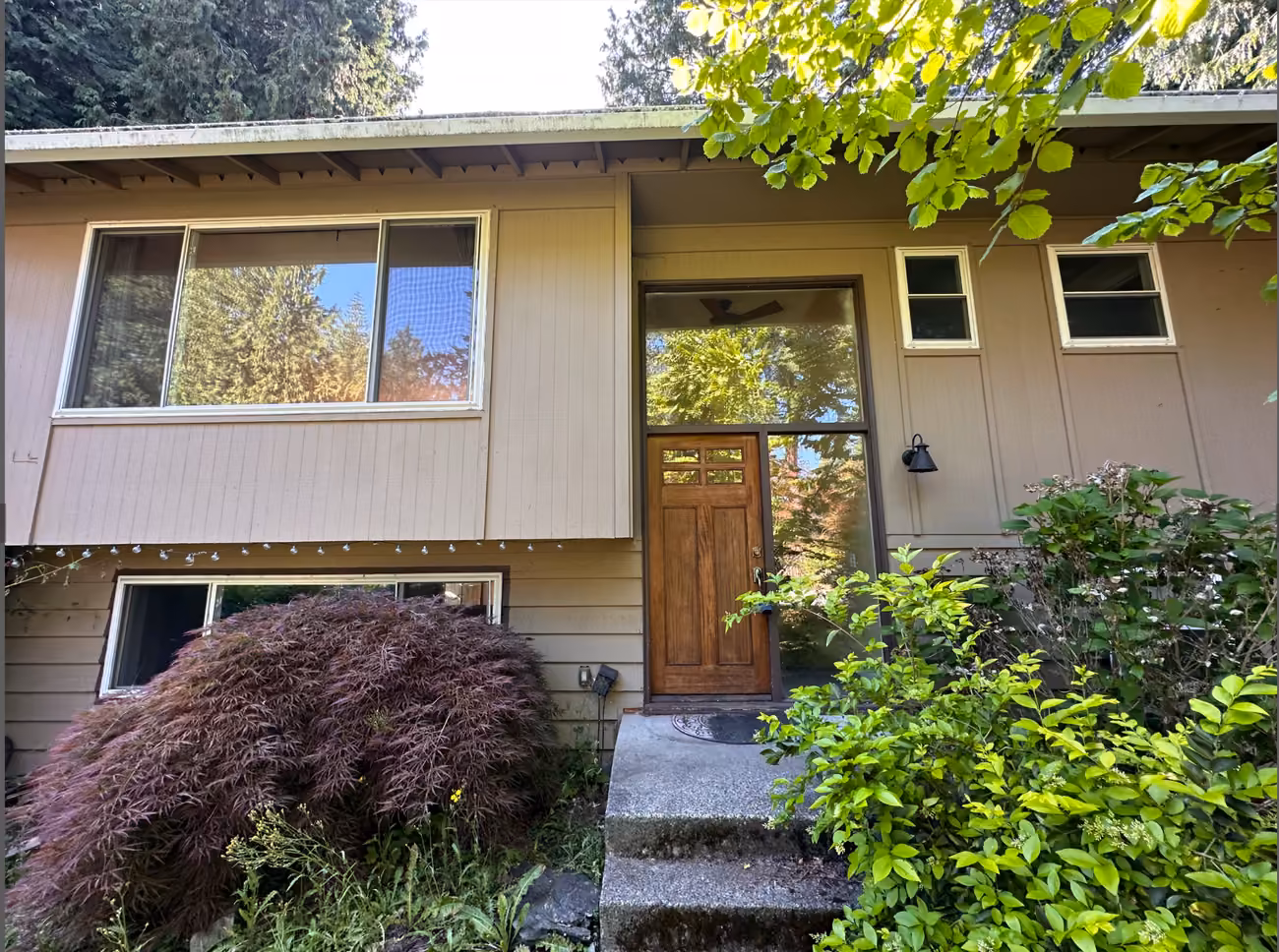 The same home before renovation, with beige siding and the original front entry