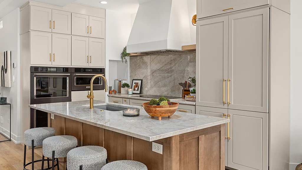 Kitchen with a wood island, white cabinets, upholstered stools, and a marble-look backsplash.