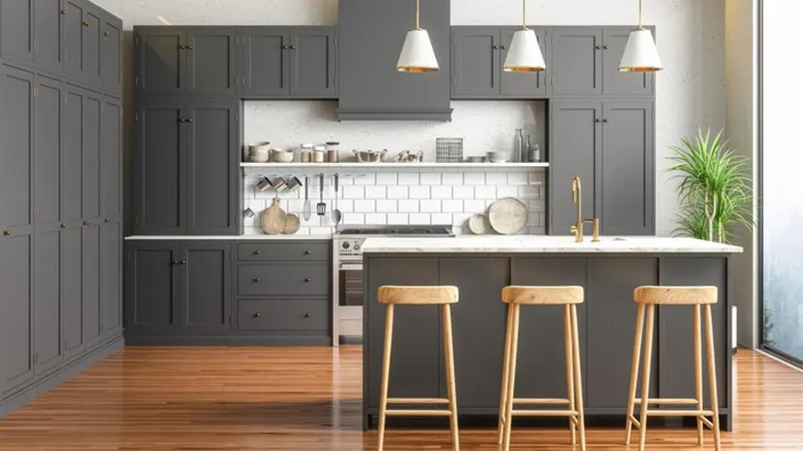 Kitchen with dark gray cabinets, island seating, wood flooring, and pendant lights.