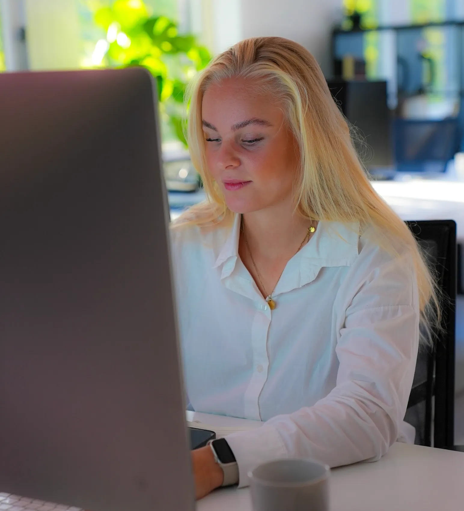 Lisette achter de computer op het GHO Agency kantoor